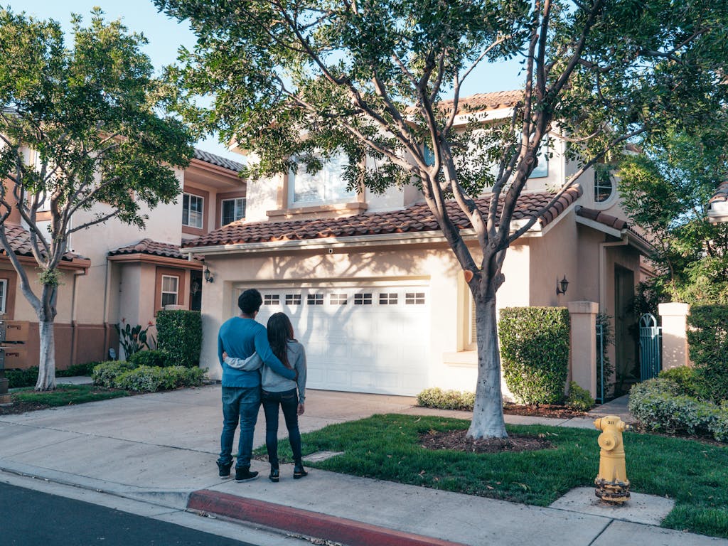 Couple hugging outside their home after repairing double car garage door with windows