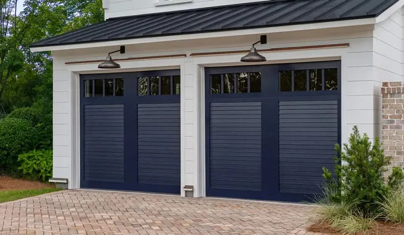 custom wooden garage doors on coastal home, wooden garages in shutter style painted navy featuring a window pane.