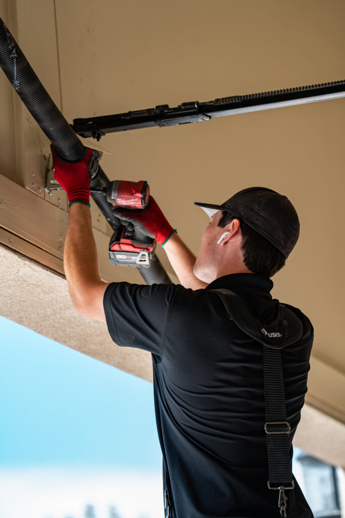Garage door repairman working on installing new garage door springs