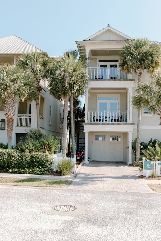 Charming three-story house with palm trees, and a fiberglass garage door, ideal beachside living.