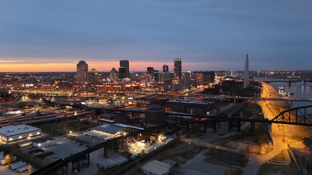 Aerial view of St. Louis, Missouri skyline at night featuring the iconic Gateway Arch.