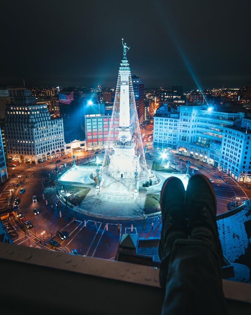 Bright night scene of Indianapolis monument surrounded by city lights.