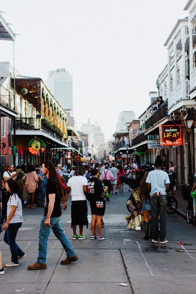 Bustling scene on Bourbon Street, New Orleans with a lively crowd enjoying an evening stroll.
